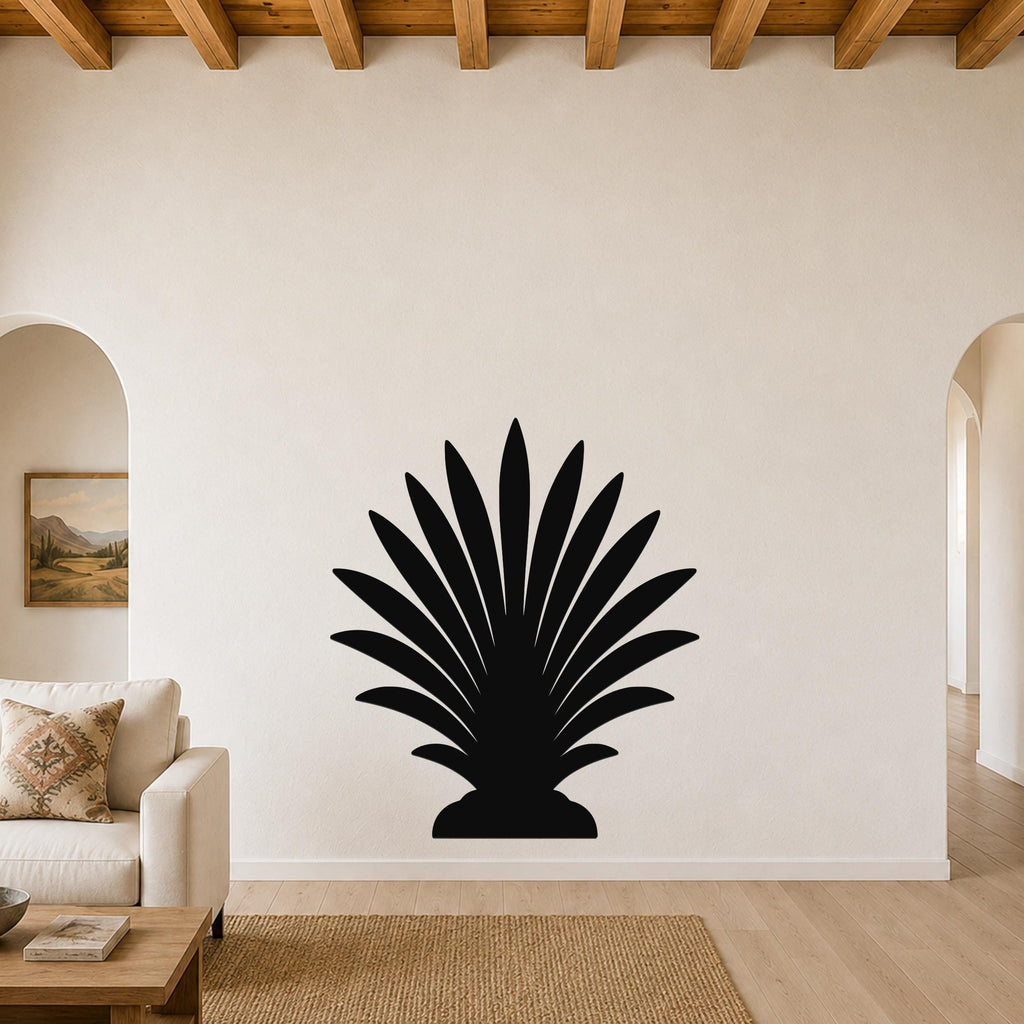 Black metal palm tree wall art with fan-shaped fronds, mounted on a living room wall above a sofa.