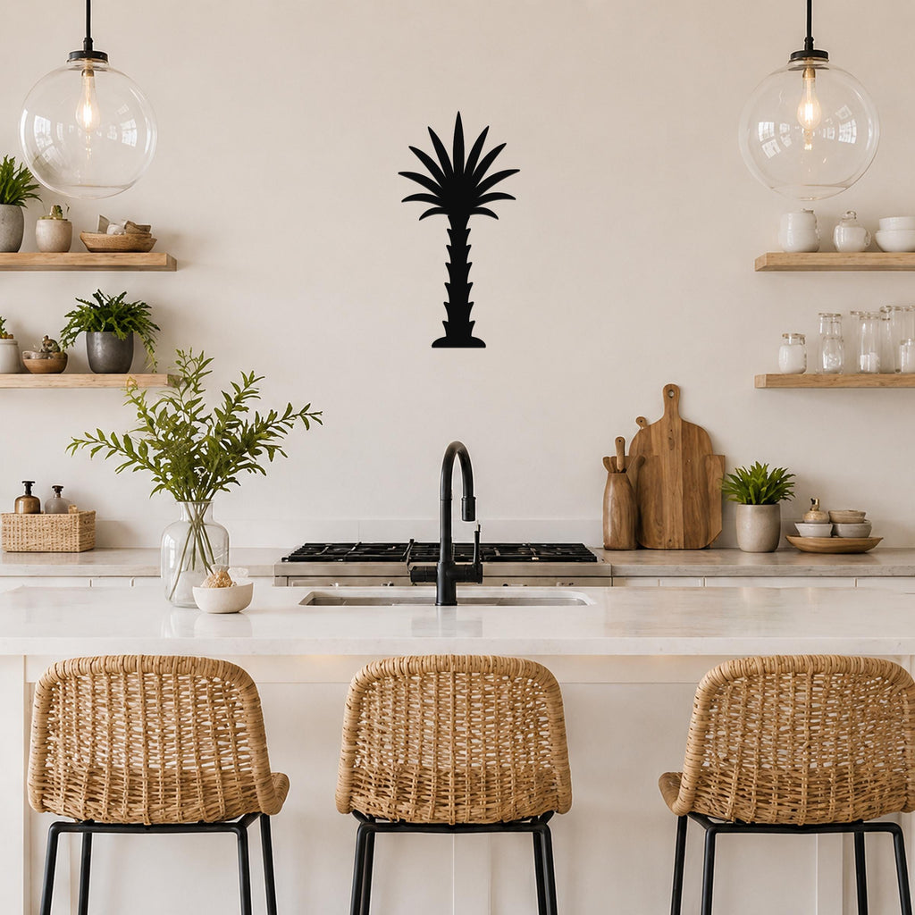 Black metal palm tree wall art silhouette mounted on a kitchen wall above a counter, with wicker bar stools and open shelving visible.
