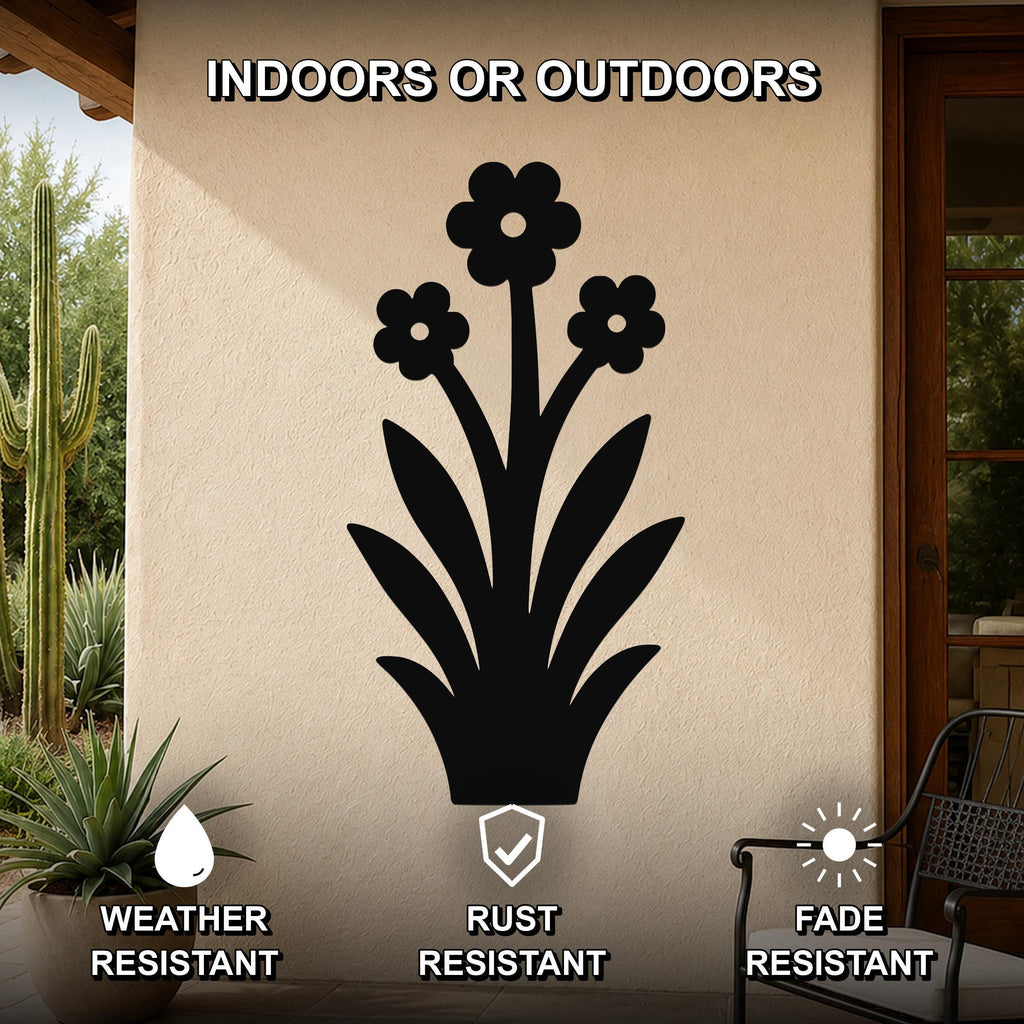 Black metal wall art featuring a silhouette of a wildflower with three blossoms and long leaves, mounted on an outdoor patio wall.