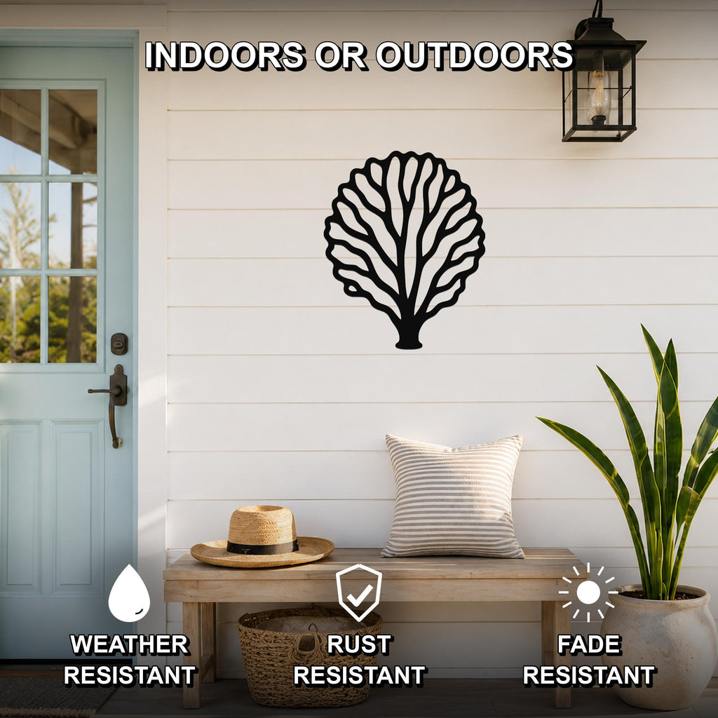 Black metal fan coral wall art with intricate branch cutouts, mounted on a white shiplap wall above a wooden bench on a porch.