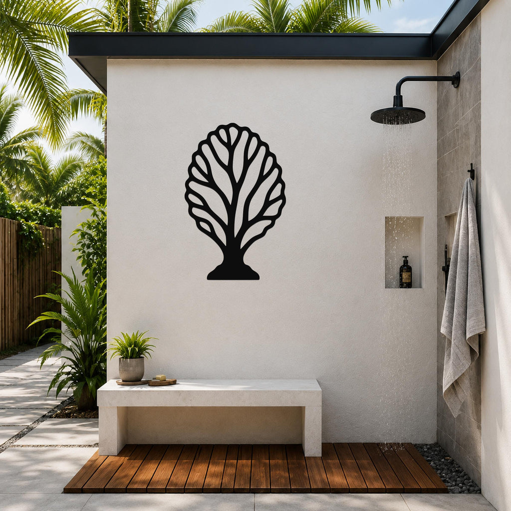 Black metal fan coral wall art with intricate branch cutouts, mounted on a white outdoor shower wall above a concrete bench.