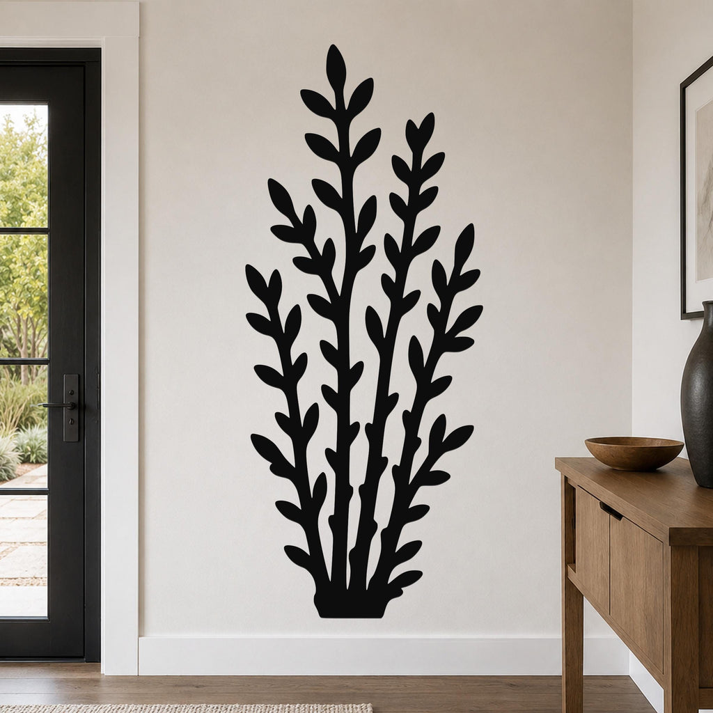 Black metal wall art in a leafy branch silhouette, mounted on a living room wall above a wooden console table.