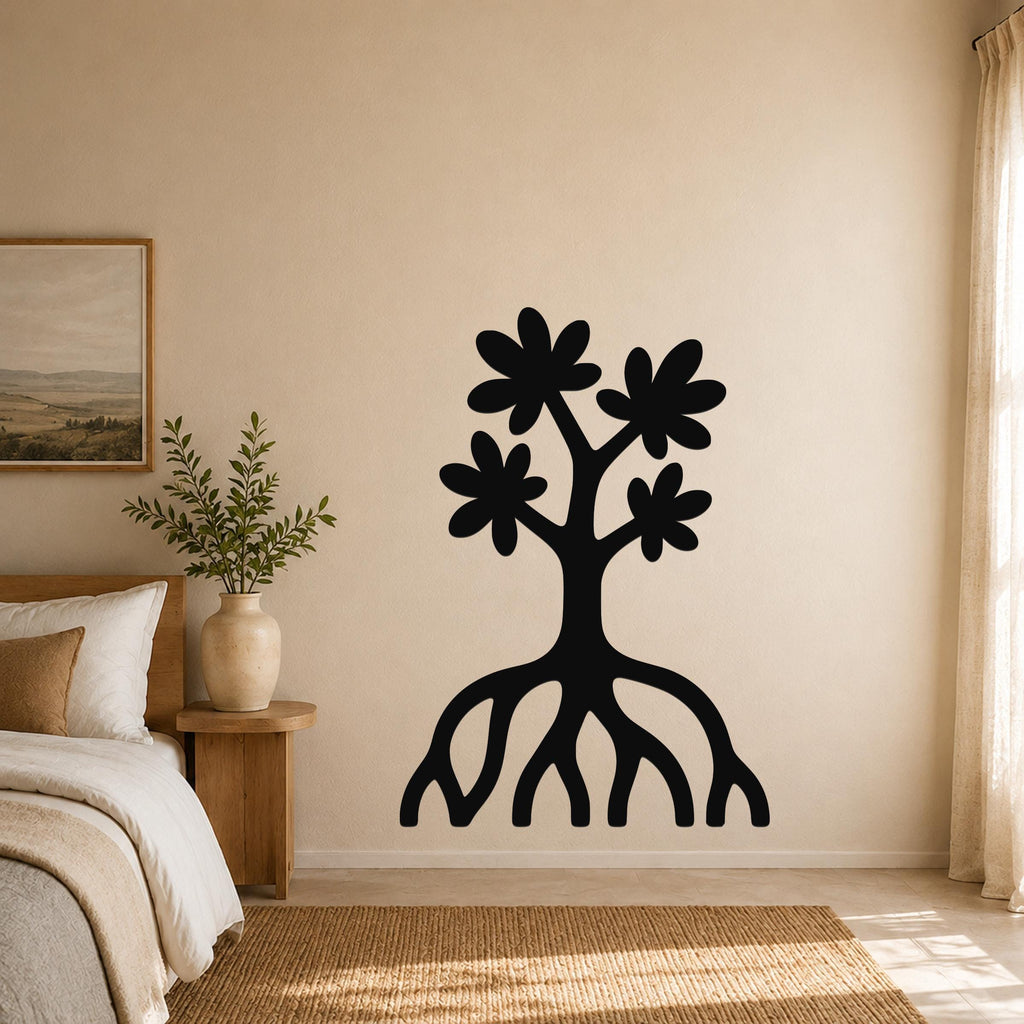 Black metal wall art in a tree silhouette with four flower shapes and exposed roots, mounted on a beige bedroom wall above a woven rug.