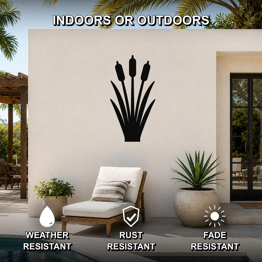 Black metal cattail wall art silhouette mounted on an outdoor patio wall, displayed above a lounge chair near a pool.