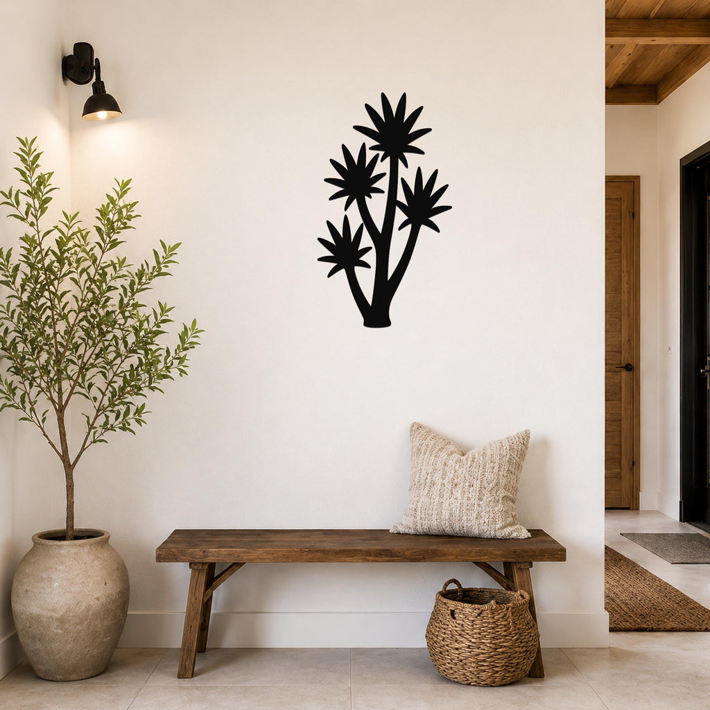 Black metal yucca wall art with multiple star-shaped leaf cutouts, mounted on a white wall above a wooden bench in a hallway.