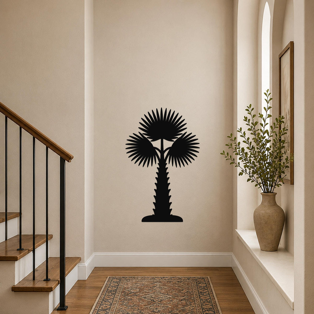 Black metal palm tree wall art with fan-shaped fronds and a textured trunk, mounted on a hallway wall above a patterned rug near a staircase.