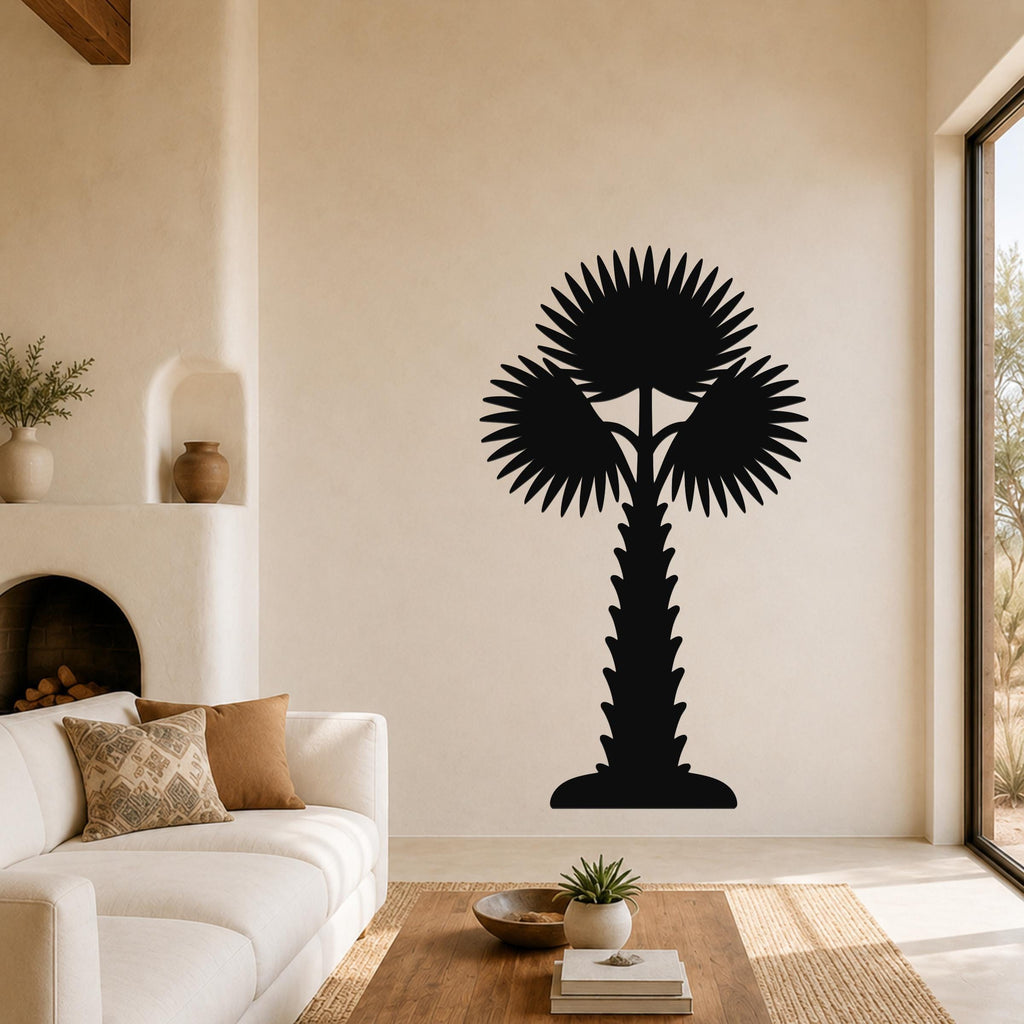 Black metal palm tree wall art with fan-shaped fronds and a textured trunk, mounted on a living room wall above a coffee table.