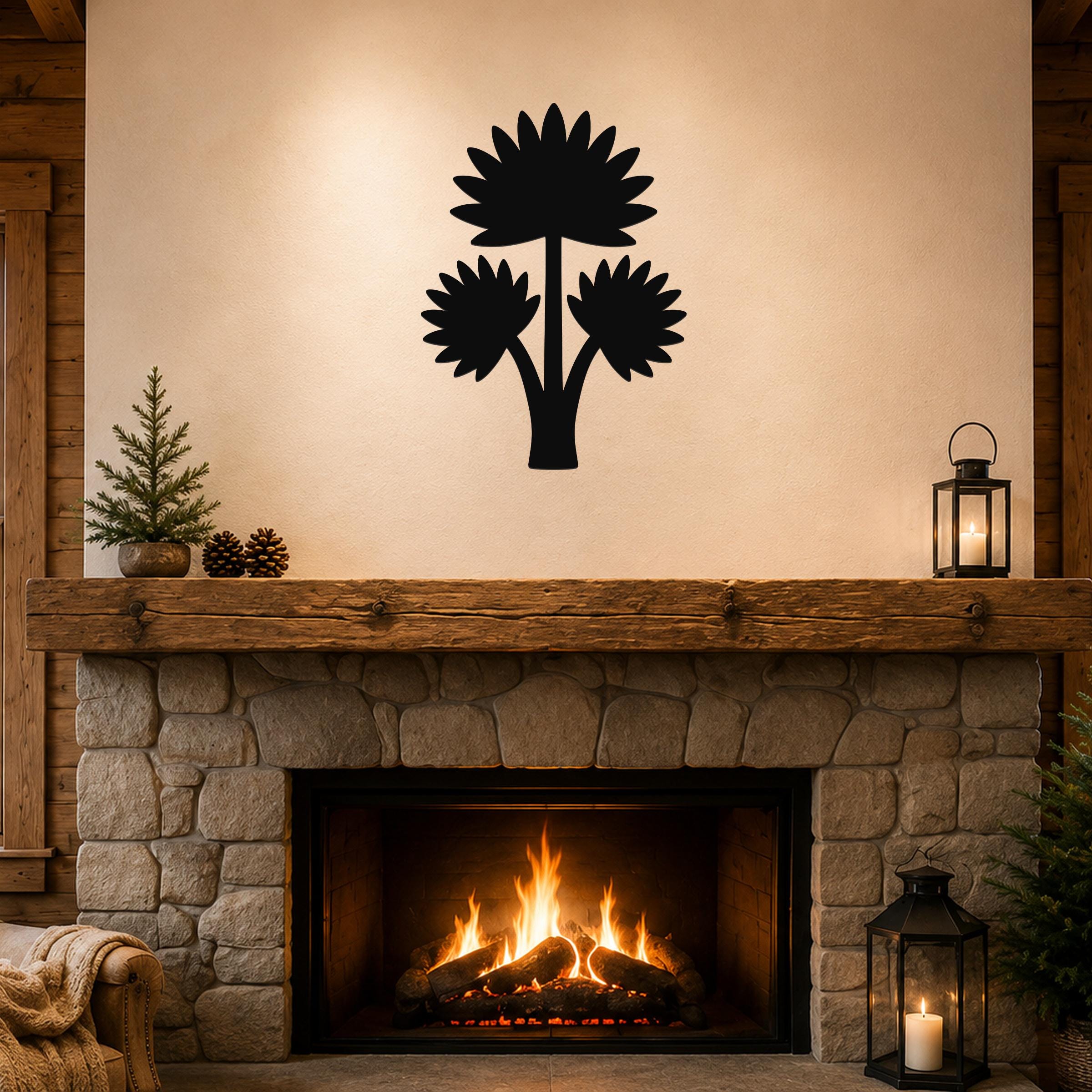 Black metal wall art cutout of a fan palm tree with three fronds, mounted above a stone fireplace in a rustic living room.