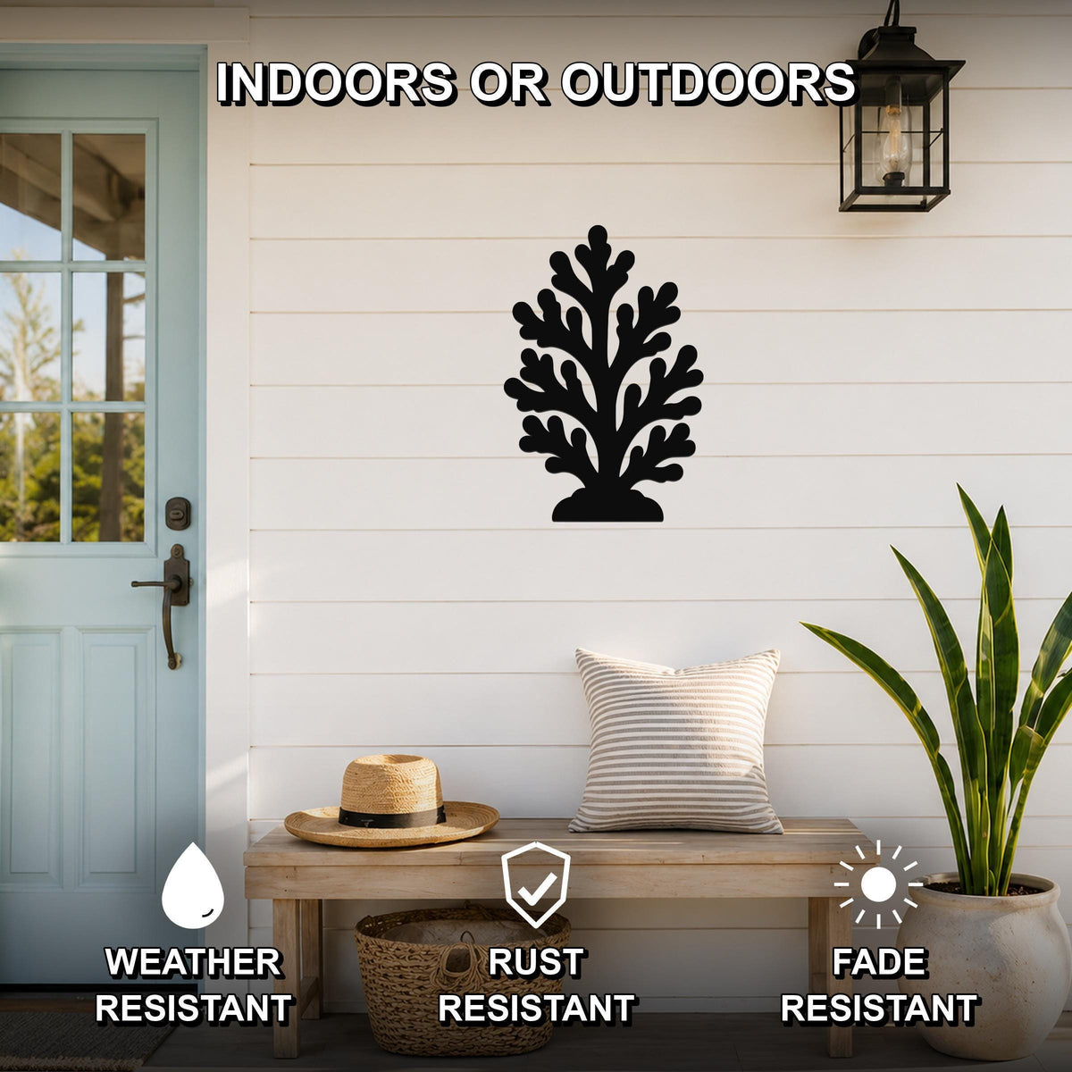 Black metal coral wall art with intricate branch cutouts, mounted on a white shiplap wall above a wooden bench on a porch.