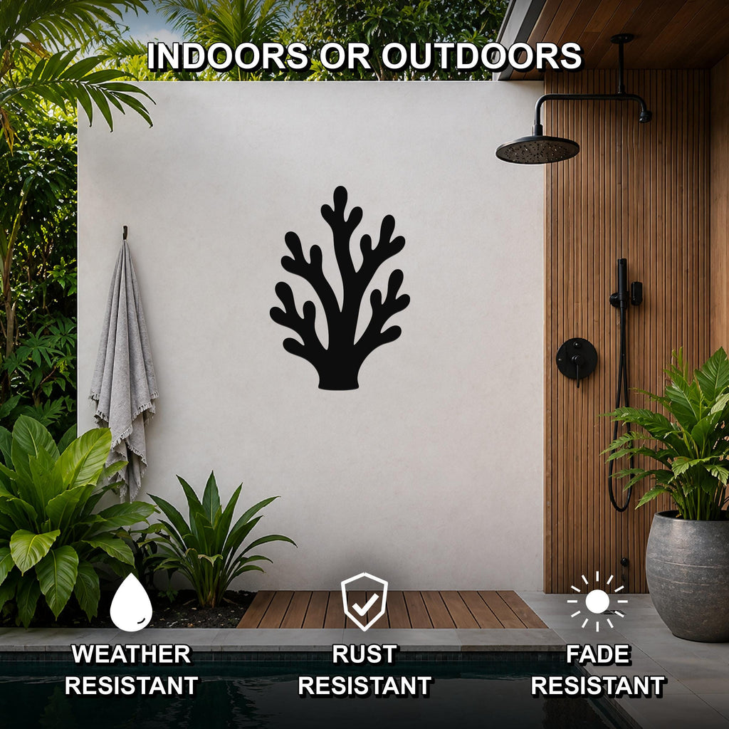Black metal branching coral wall art with intricate cutout details, mounted on a light-colored outdoor wall beside a wooden shower enclosure and pool.