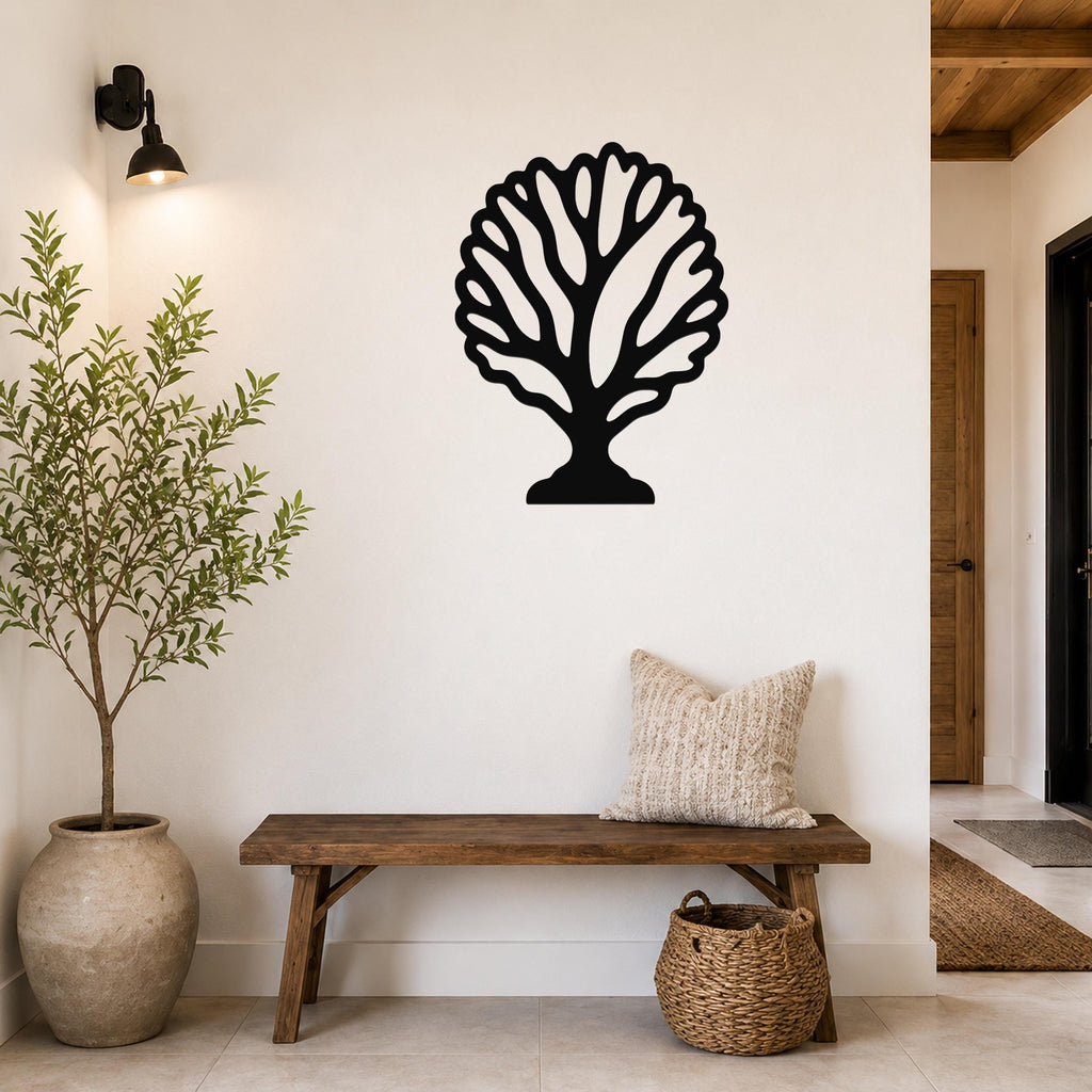 Black metal fan coral wall art with intricate branch cutouts, mounted on a white wall above a wooden bench in a entryway.