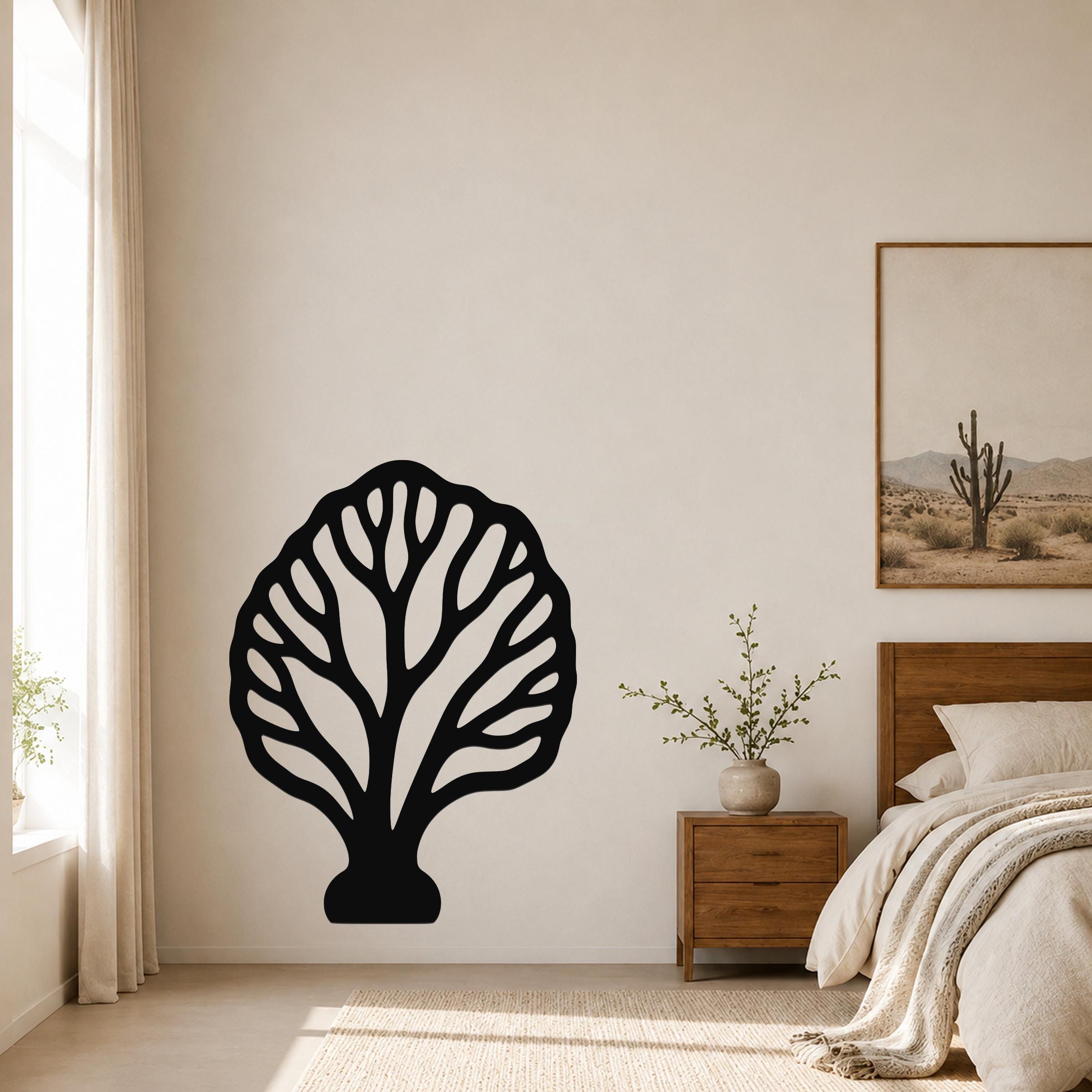 Black metal fan coral wall art with intricate branch cutouts, mounted on a bedroom wall above a wooden nightstand.