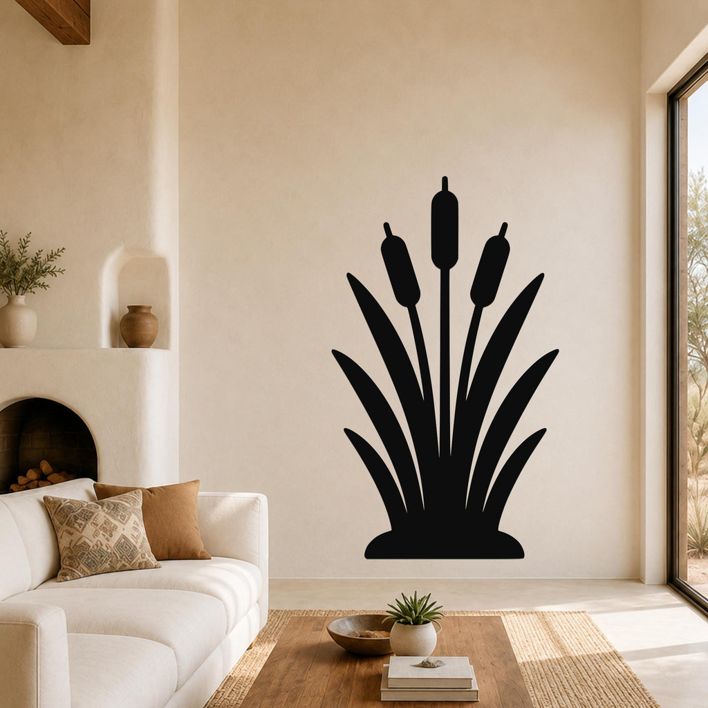Black metal cattail wall art silhouette with three seed heads and long leaves, mounted on a living room wall above a sofa.