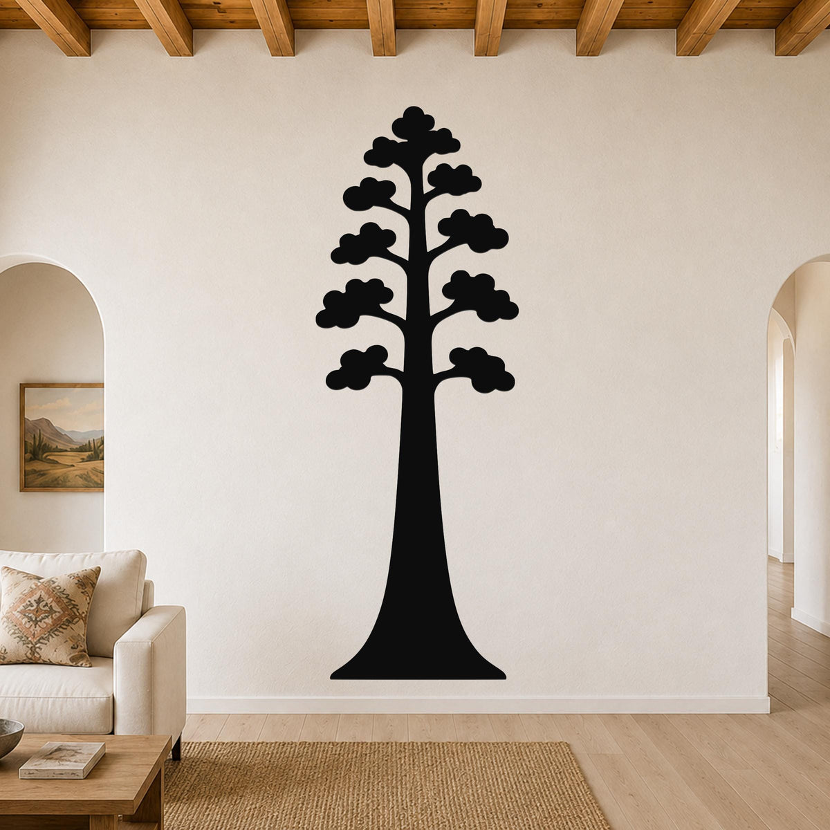 Black metal sequoia tree wall art with layered branch cutouts, mounted on a living room wall above a sofa.