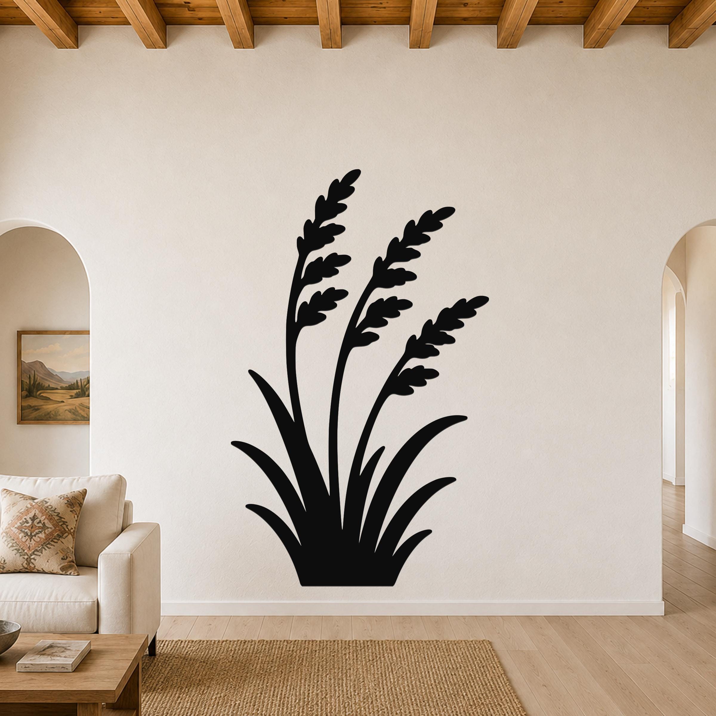 Black metal wall art in a wild grass silhouette design, mounted on a living room wall above a sofa.