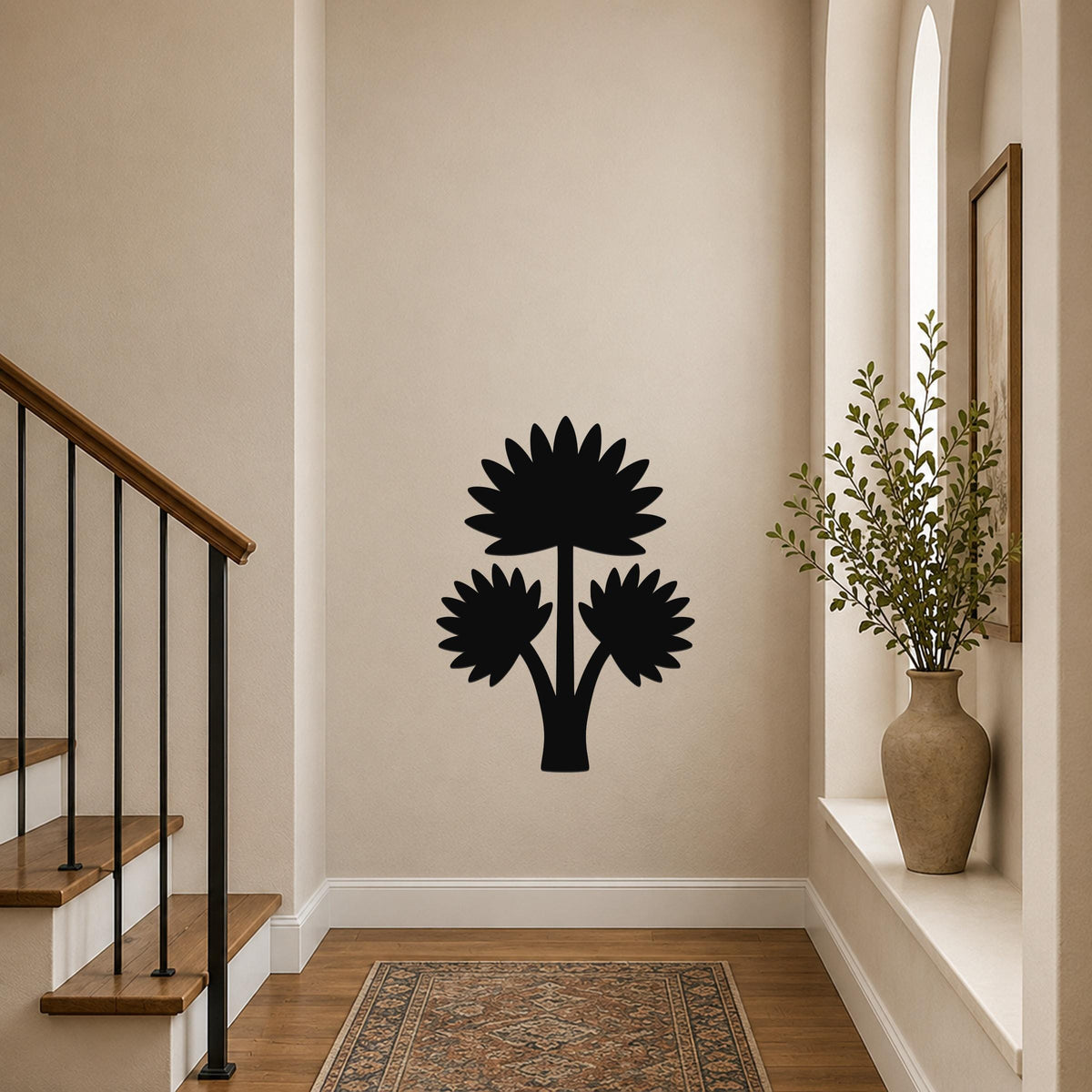 Black metal wall art featuring a fan palm tree silhouette with three flower-like fronds, mounted on a hallway wall above a patterned rug near a staircase.