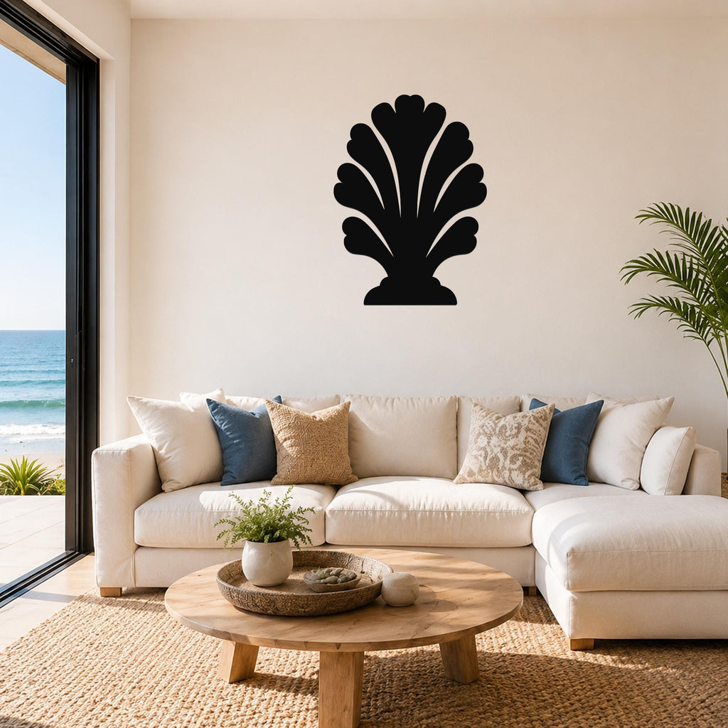 Black metal wall art in a coral or shell silhouette design, mounted on a living room wall above a white sofa.