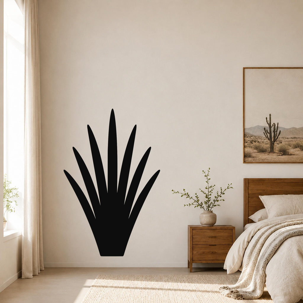 Black metal yucca wall art silhouette mounted on a bedroom wall above a wooden nightstand.