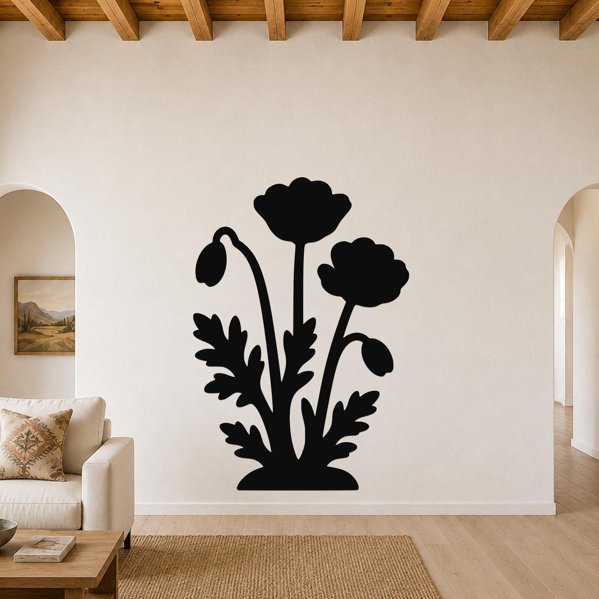 Black metal wall art featuring a silhouette of three poppy flowers and leaves, mounted on a living room wall above a sofa.