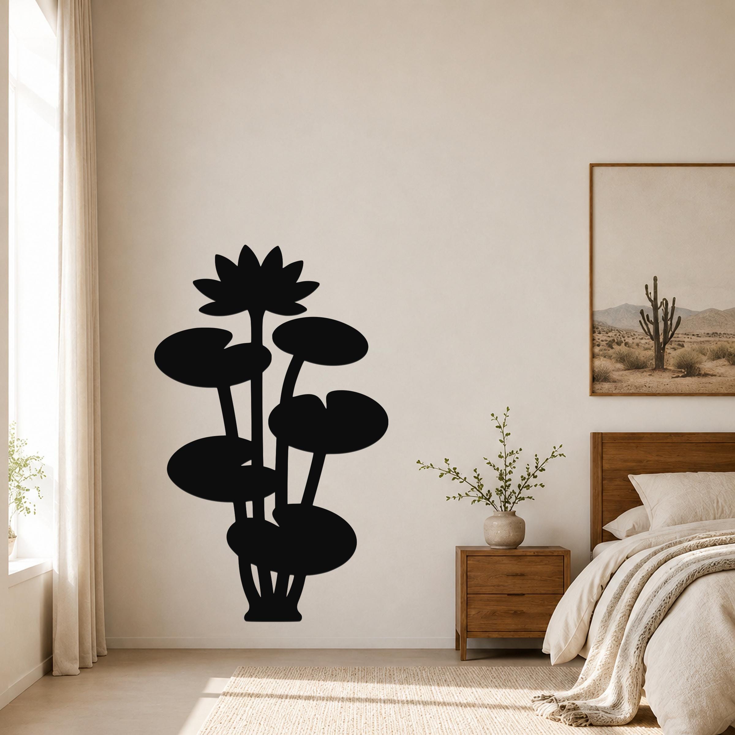 Black metal lotus water lily wall art with layered flower and leaf cutouts, mounted on a bedroom wall above a wooden nightstand.