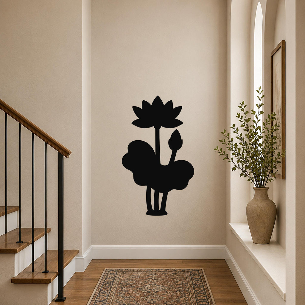 Black metal wall art silhouette of a lotus flower and lily pad, mounted on a hallway wall near a staircase and a potted plant.