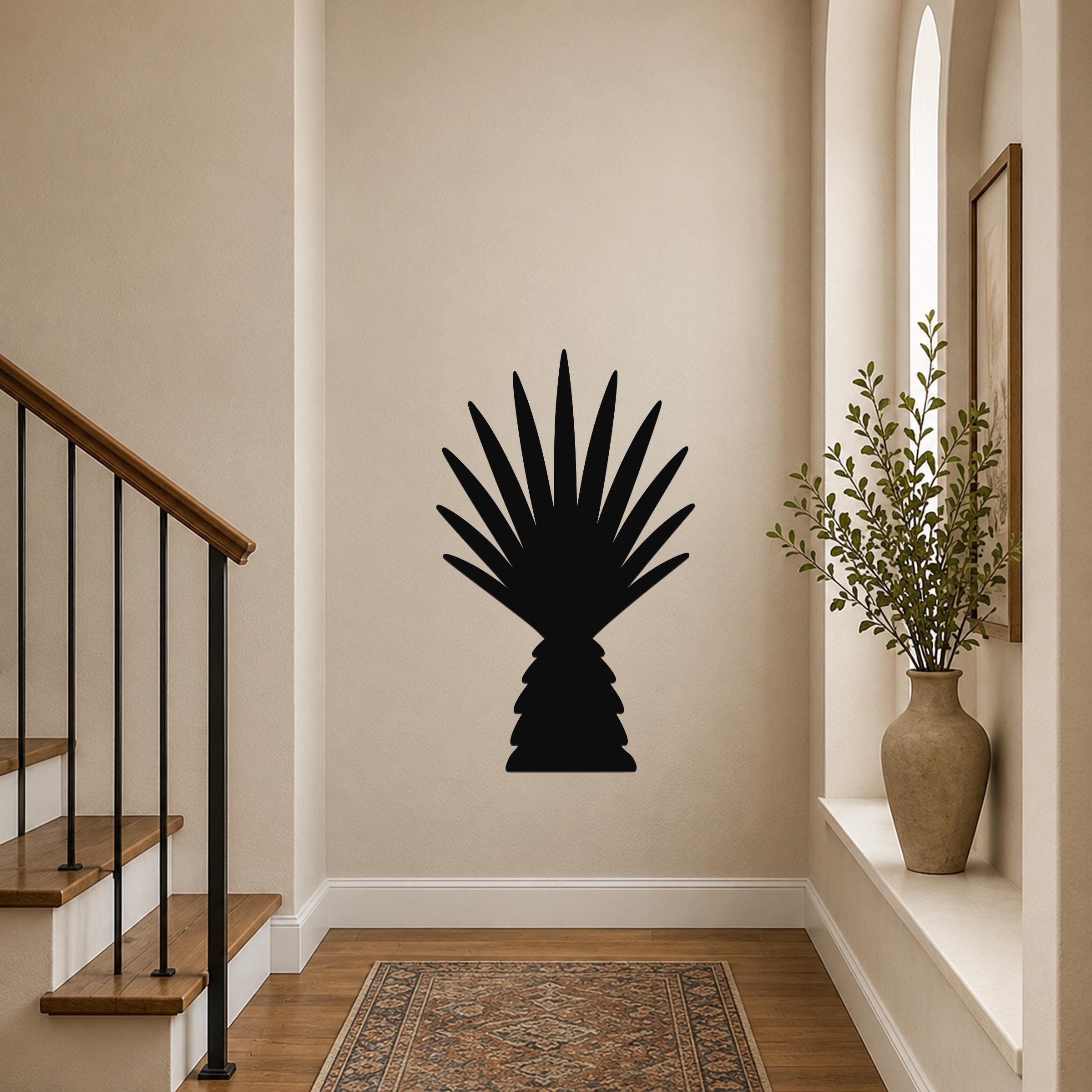 Black metal palm tree wall art with fan-shaped fronds, mounted on a hallway wall above a patterned rug near a staircase.