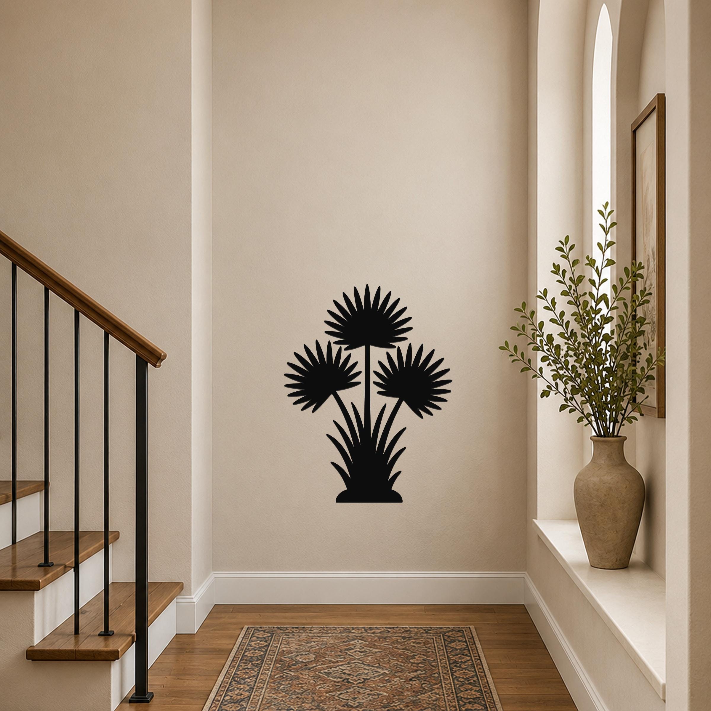 Black metal wall art silhouette of a fan palm tree with three fronds, mounted on a hallway wall above a patterned rug near a staircase.