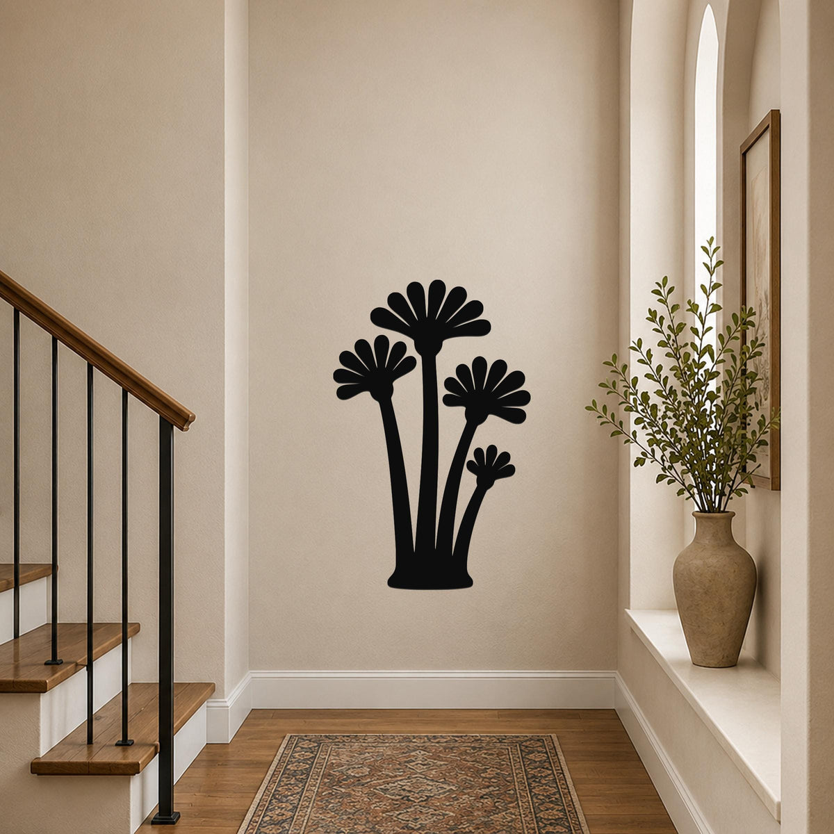 Black metal wall art with a fan palm tree silhouette, mounted on a hallway wall above a patterned rug near a staircase.