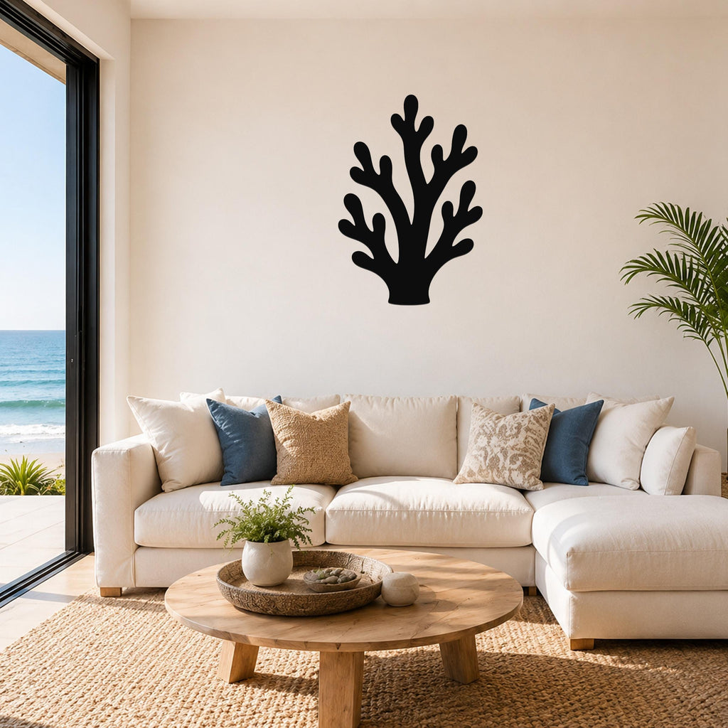Black metal branching coral wall art with cutout details, mounted on a living room wall above a white sectional sofa.