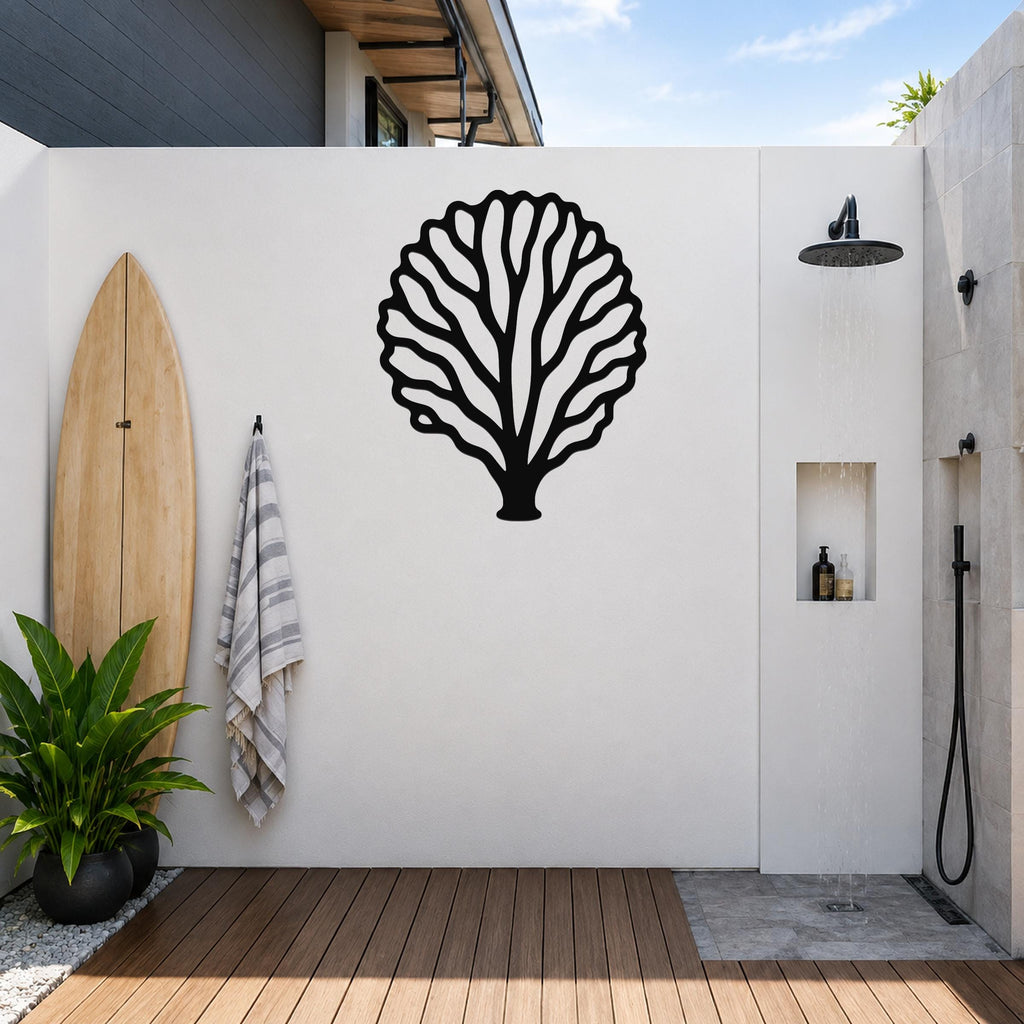 Black metal fan coral wall art with intricate branch cutouts, mounted on a white outdoor wall above a wooden deck near a shower area.