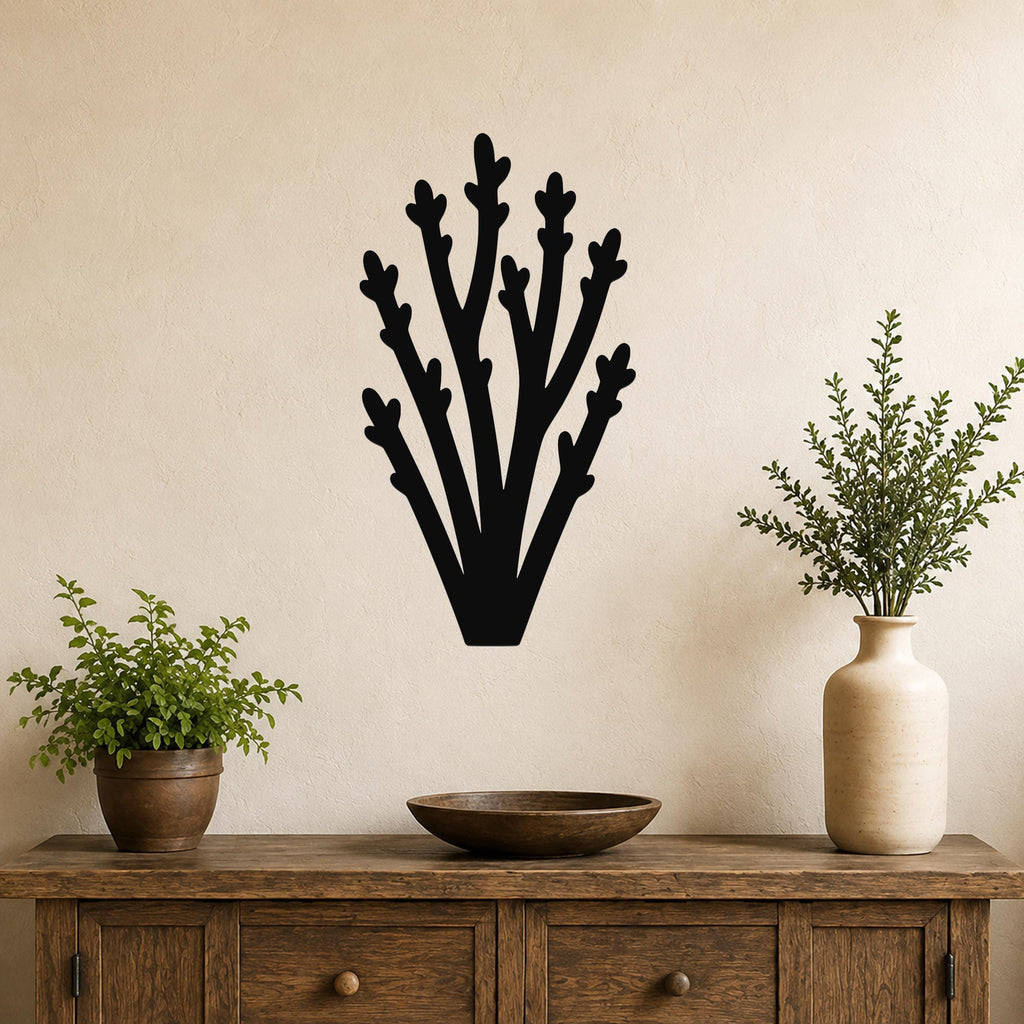 Black metal wall art in a branching silhouette design, mounted on a beige wall above a wooden console table with potted plants.