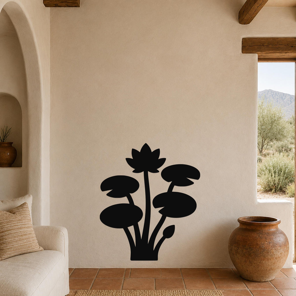 Black metal lotus water lily wall art with silhouette cutouts of flowers and leaves, mounted on a beige living room wall above a sofa.
