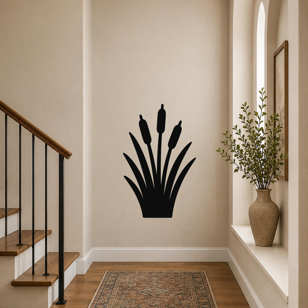 Black metal cattail wall art silhouette with three seed heads and leafy base, mounted on a hallway wall near a staircase and window.