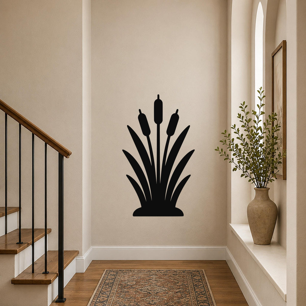 Black metal cattail wall art silhouette with three seed heads and leafy base, mounted on a hallway wall above a patterned rug near a staircase.