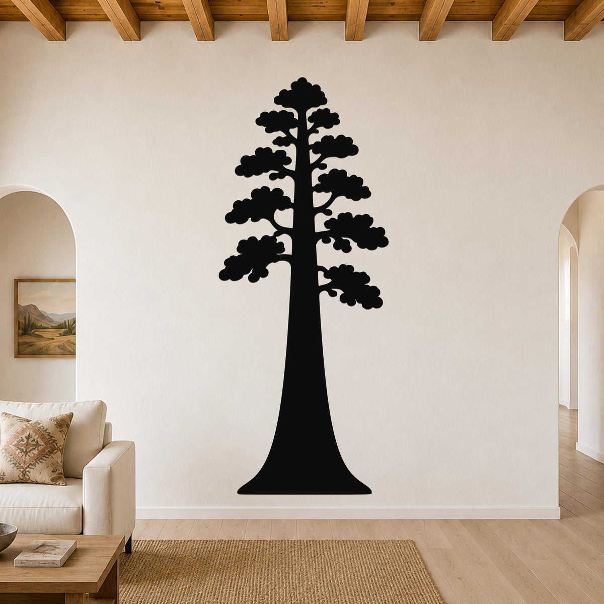 Black metal wall art of a sequoia tree silhouette, mounted on a living room wall above a sofa.