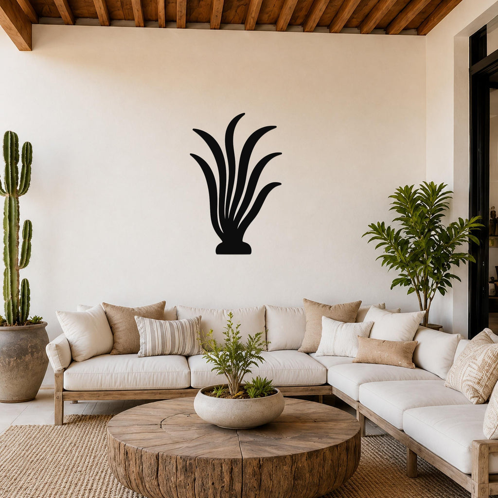 Black metal kelp wall art silhouette mounted on a living room wall above a white sofa.