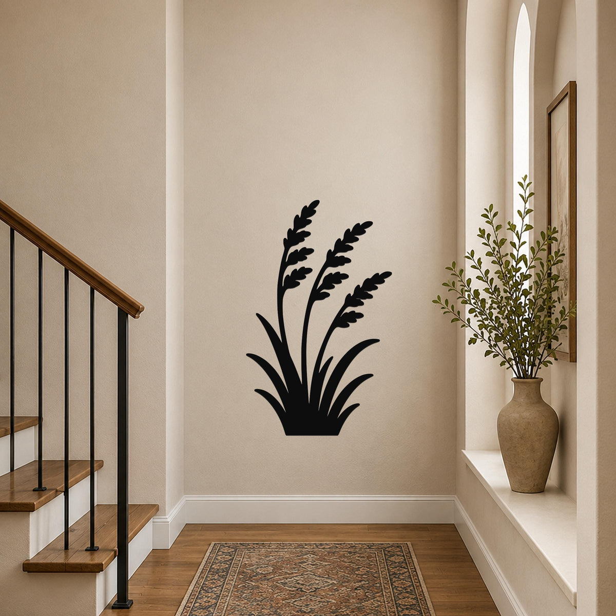 Black metal wall art in a wild grass silhouette design, mounted on a hallway wall above a patterned rug near a staircase.