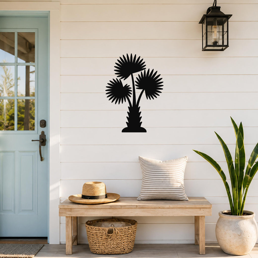 Black metal palm tree wall art with three fan-shaped fronds, mounted on a white shiplap wall above a wooden bench in a porch entryway.