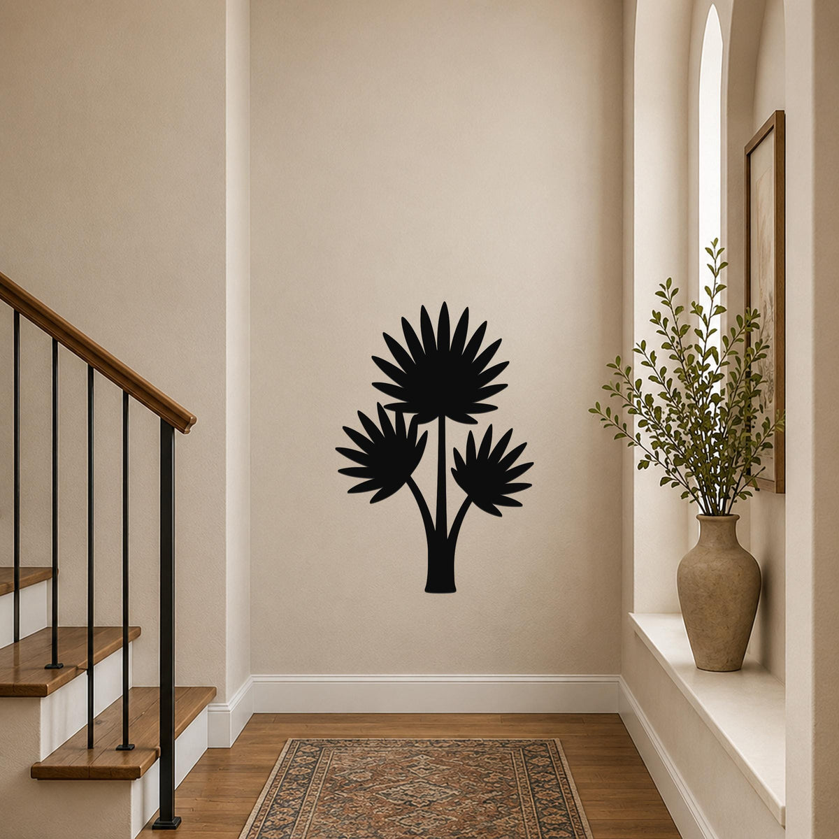 Black metal wall art silhouette of a fan palm tree with three fronds, mounted on a hallway wall above a patterned rug near a staircase.
