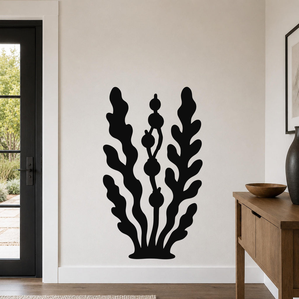 Black metal wall art in a kelp and seaweed silhouette design, mounted on a living room wall above a wooden console table.
