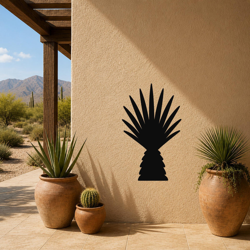 Black metal wall art cutout of a fan palm tree, mounted on a stucco patio wall above terracotta pots with cacti and succulents.