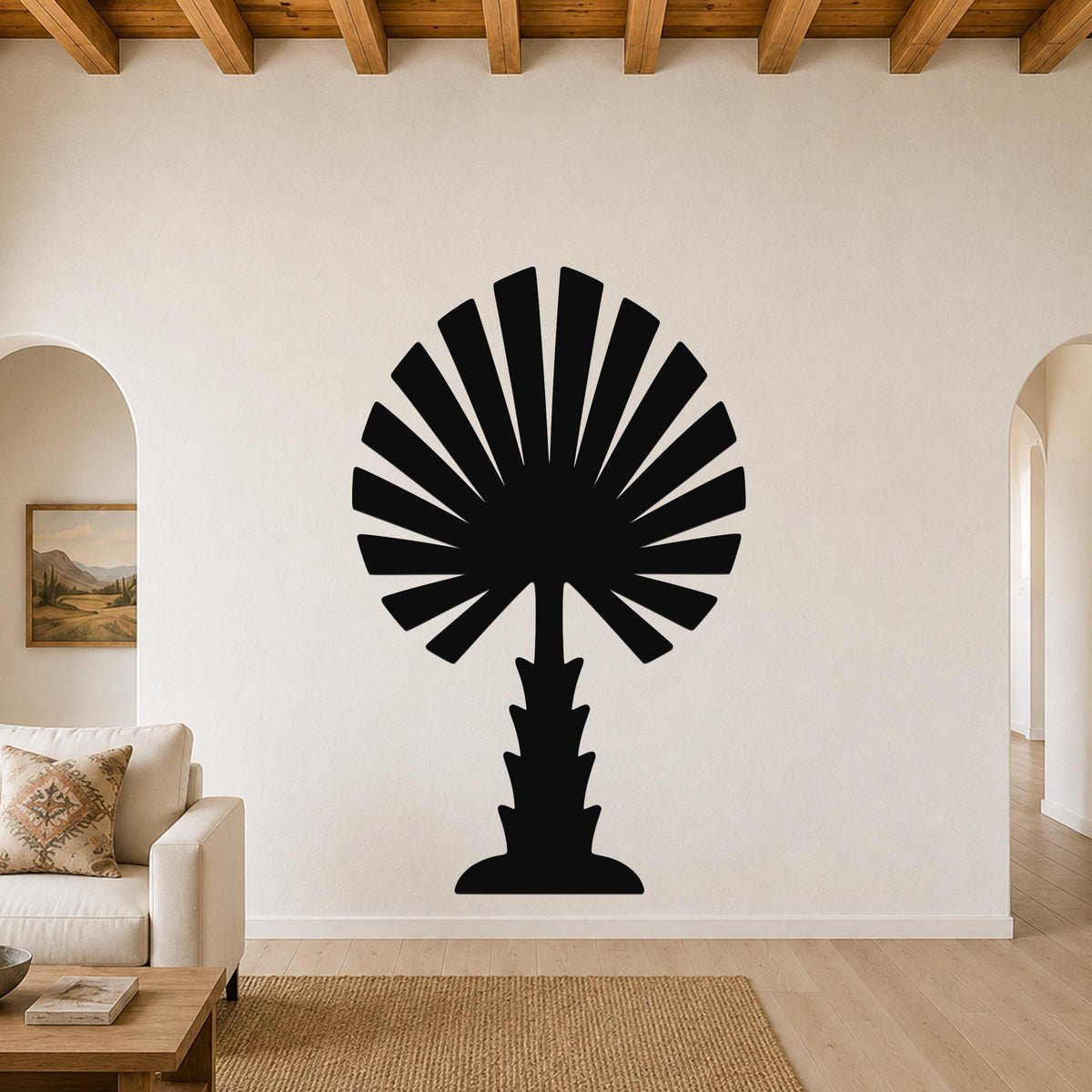 Black metal palm tree wall art with fan-shaped fronds, mounted on a living room wall above a sofa.