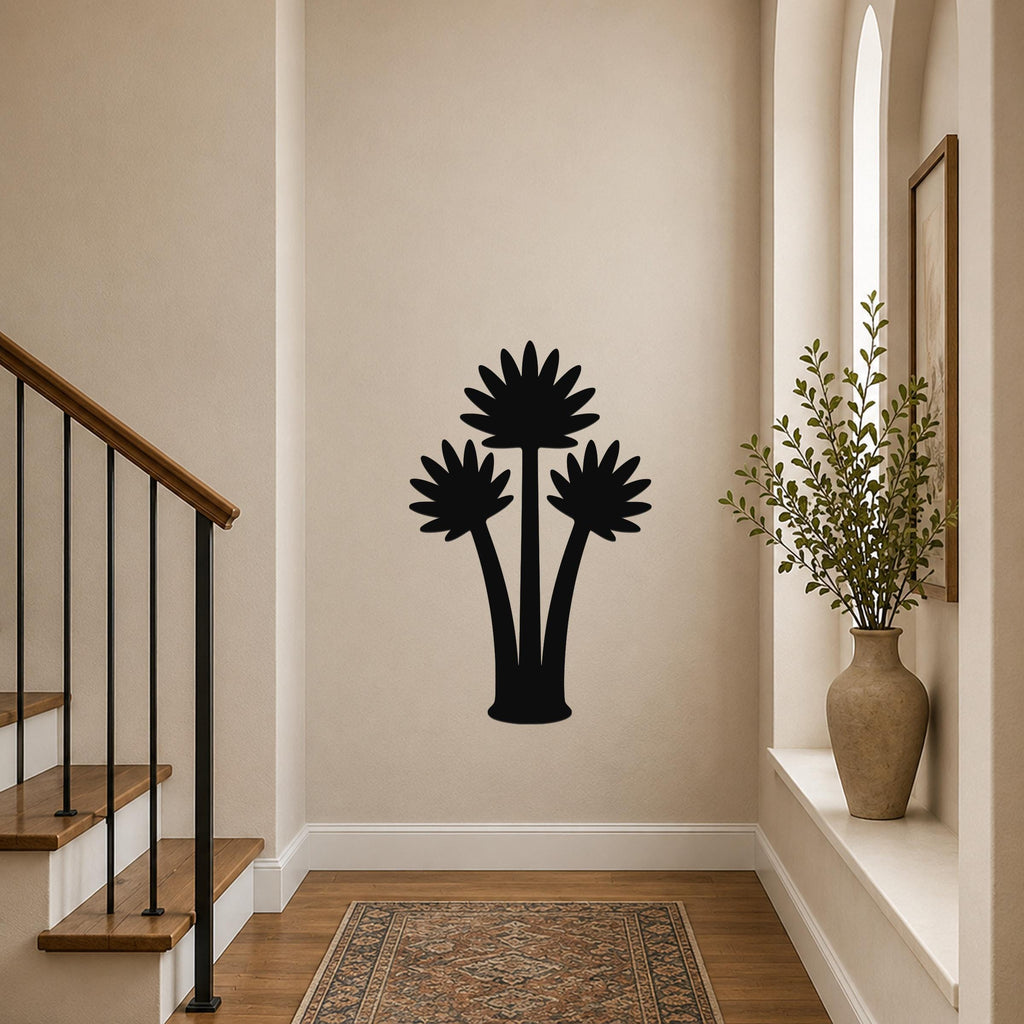 Black metal wall art featuring a fan palm tree silhouette, mounted on a hallway wall above a patterned rug near a staircase.