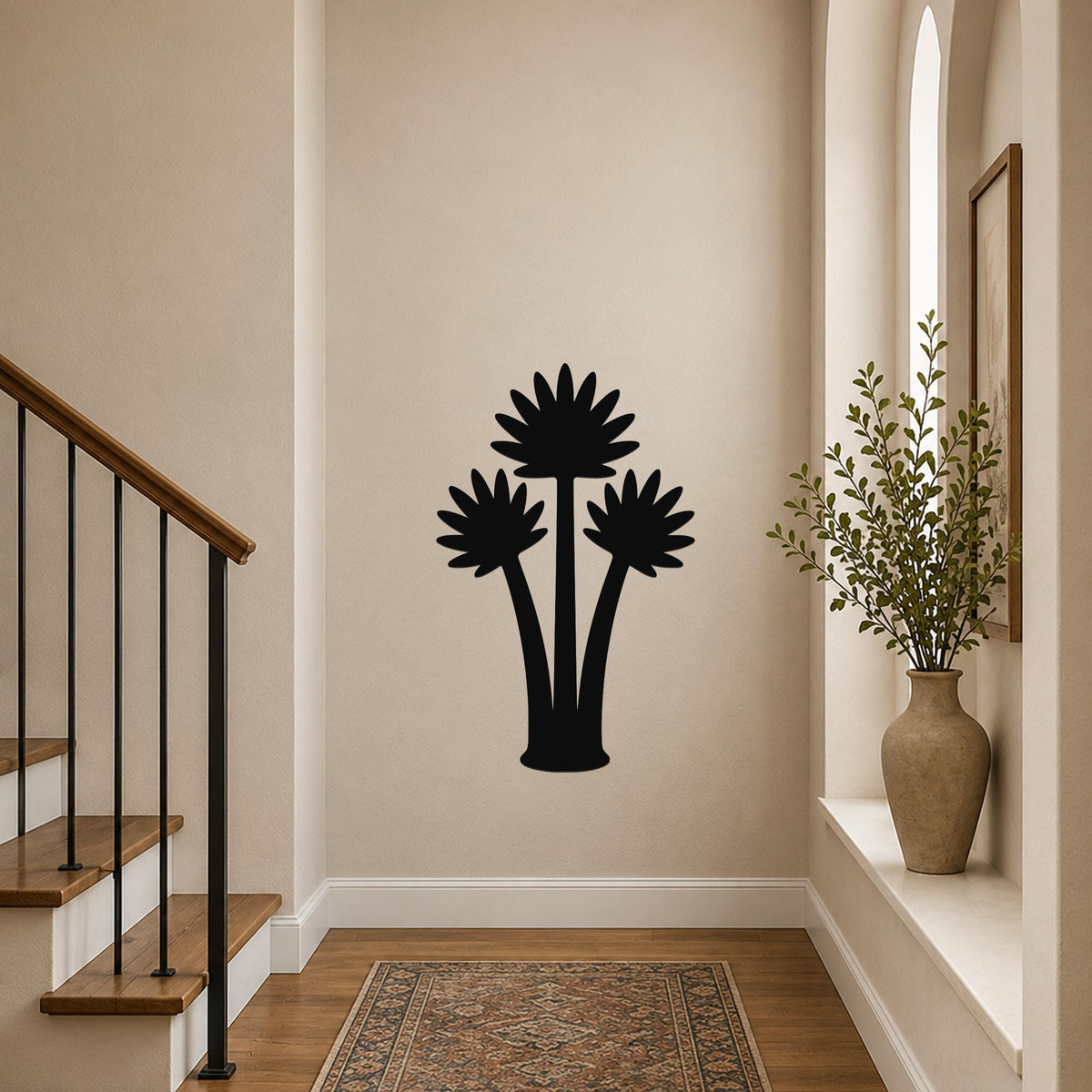 Black metal wall art featuring a fan palm tree silhouette, mounted on a hallway wall above a patterned rug near a staircase.