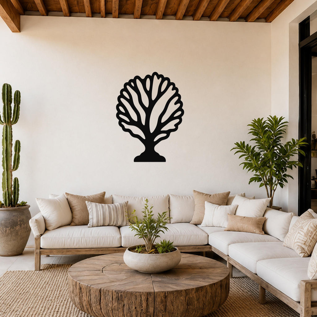 Black metal fan coral wall art with intricate branch cutouts, mounted on a white wall above a white sofa in a living room.