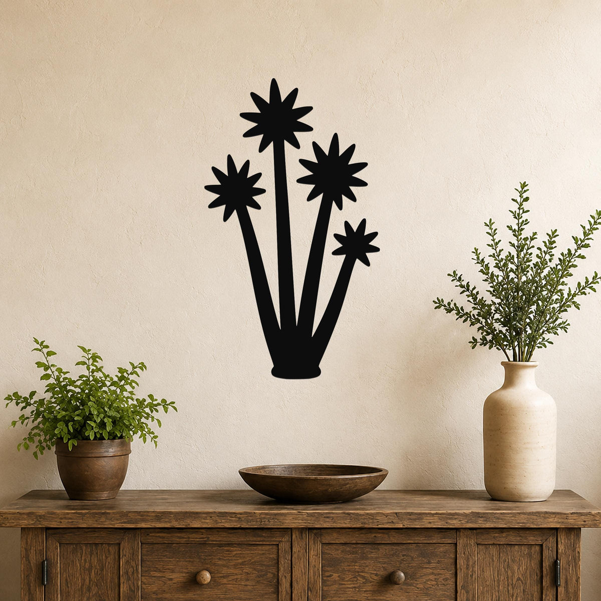 Black metal yucca wall art with star-shaped bloom cutouts, mounted on a beige wall above a wooden console table in a living room.