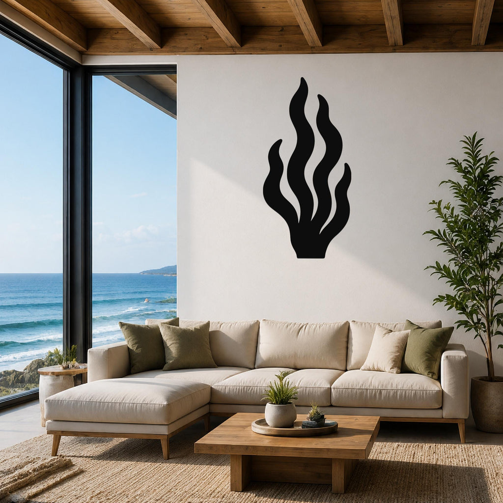 Black metal kelp wall art with flowing frond cutouts, mounted on a white living room wall above a beige sectional sofa.