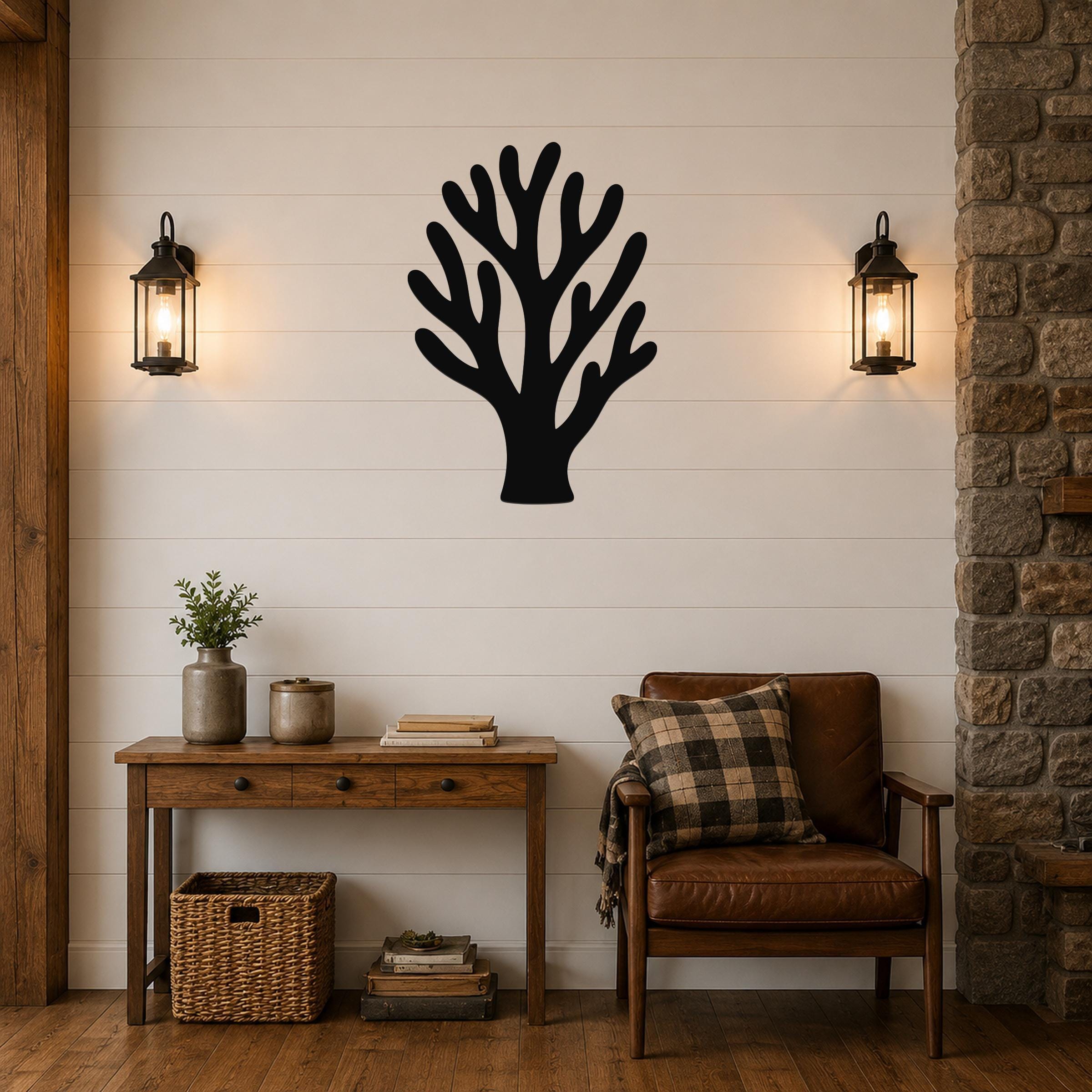 Black metal coral wall art with branching cutouts, mounted on a shiplap wall above a wooden console table in a living room.