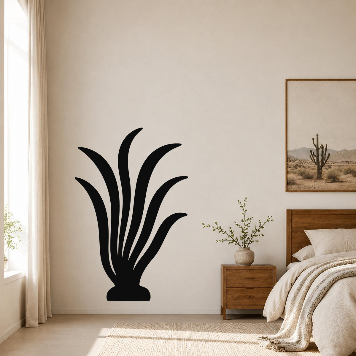 Black metal kelp wall art with flowing leaf-like cutouts, mounted on a bedroom wall above a wooden nightstand.