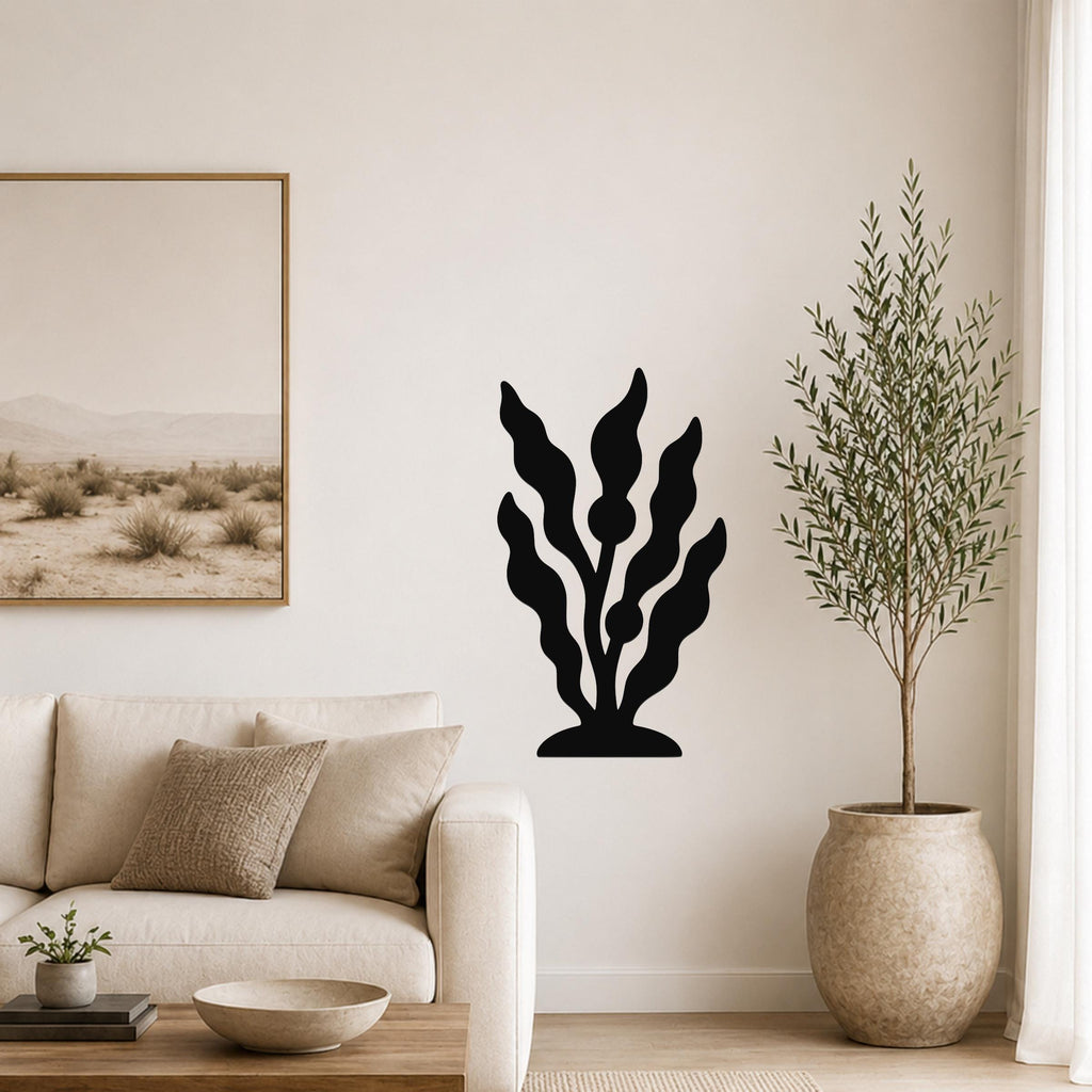 Black metal kelp wall art with wavy leaf cutouts, mounted on a living room wall above a sofa.